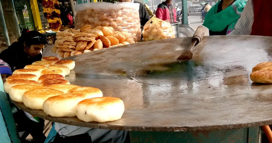 Gefüllte Kulchas garen auf einer großen runden Grillplatte an einem Straßenstand